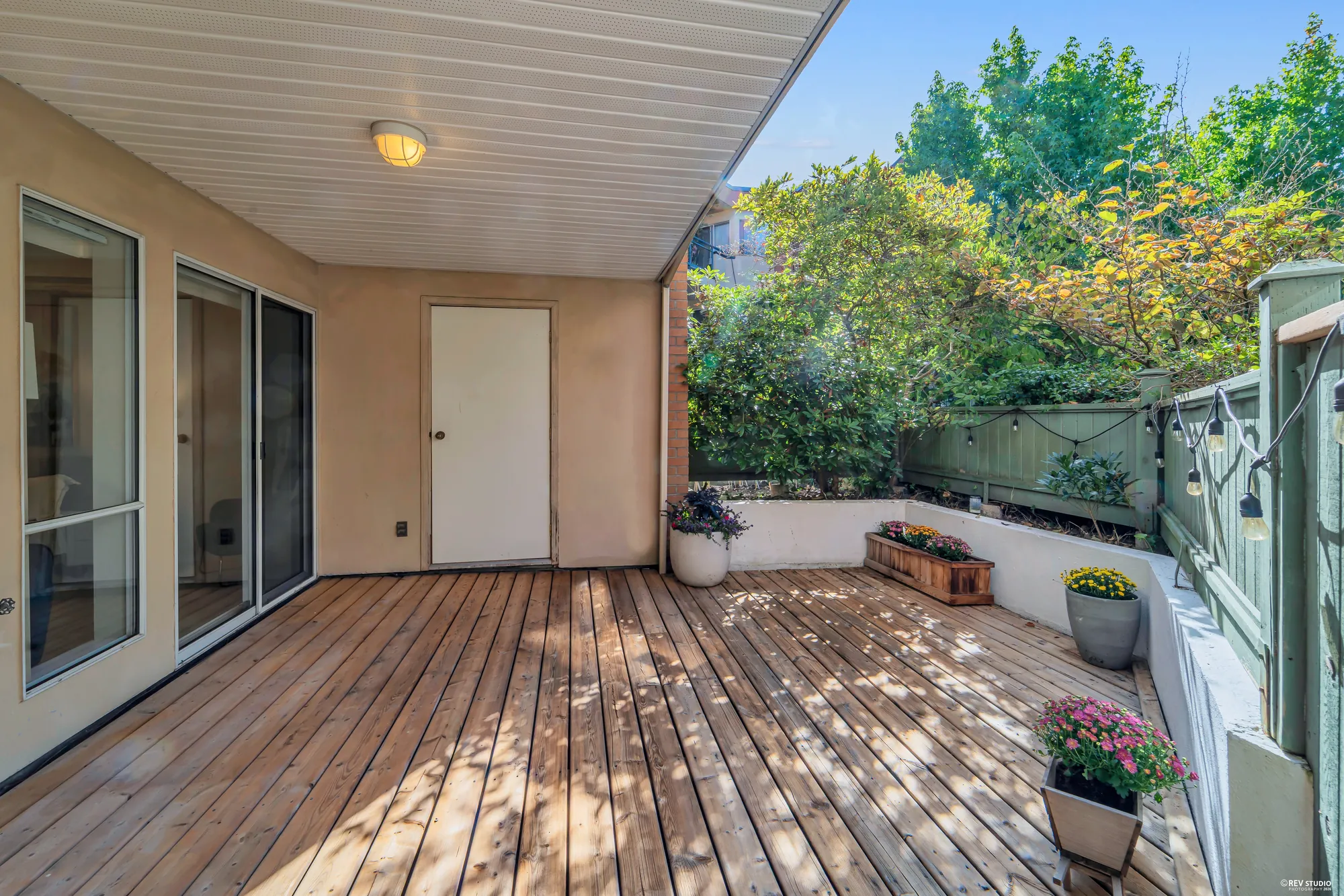 The deck from the living room door: boards, planters, the storage room door