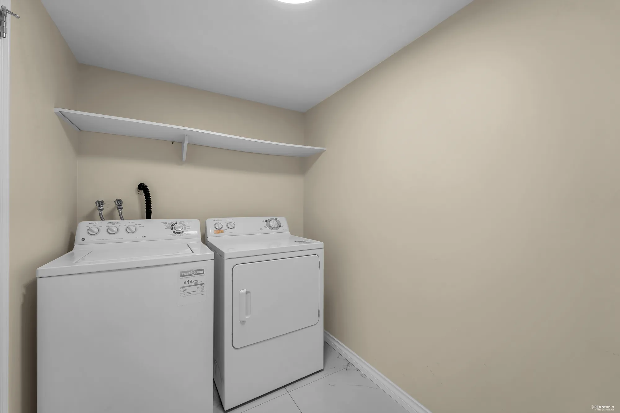 The laundry room: side-by-side washer and dryer with a shelf